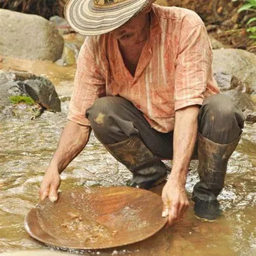Minero trabajando con batea en el agua